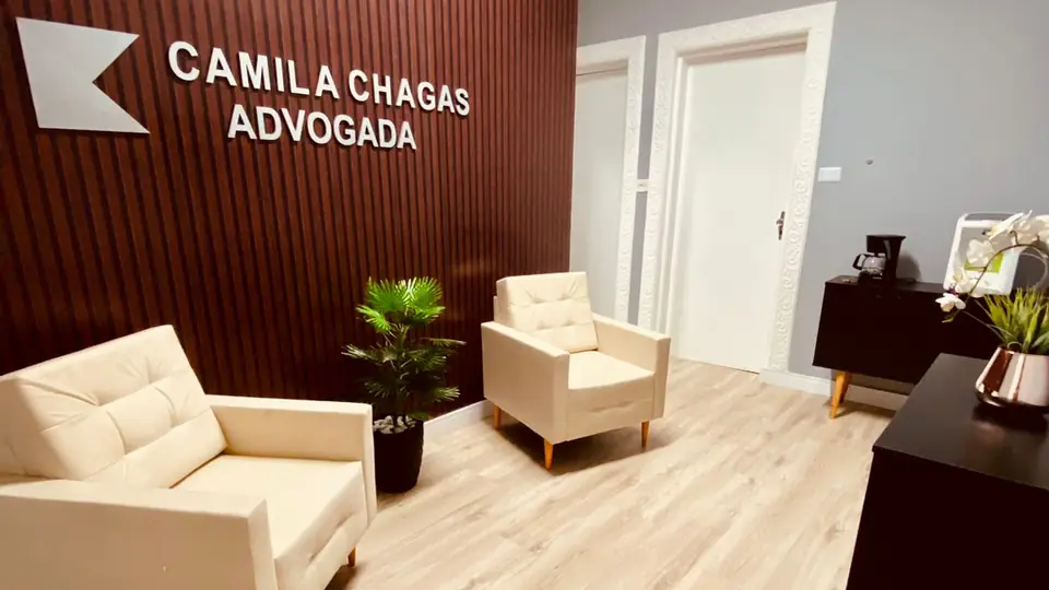 Recepção do escritório, com o nome Camila Chagas Advogada na parede ripada