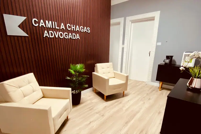 Recepção do escritório, com o nome Camila Chagas Advogada na parede ripada